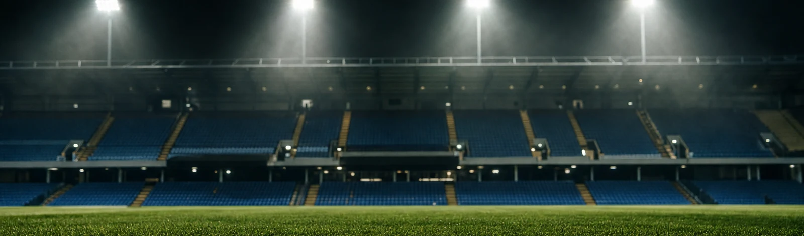 An empty football pitch under four floodlight pylons at night
