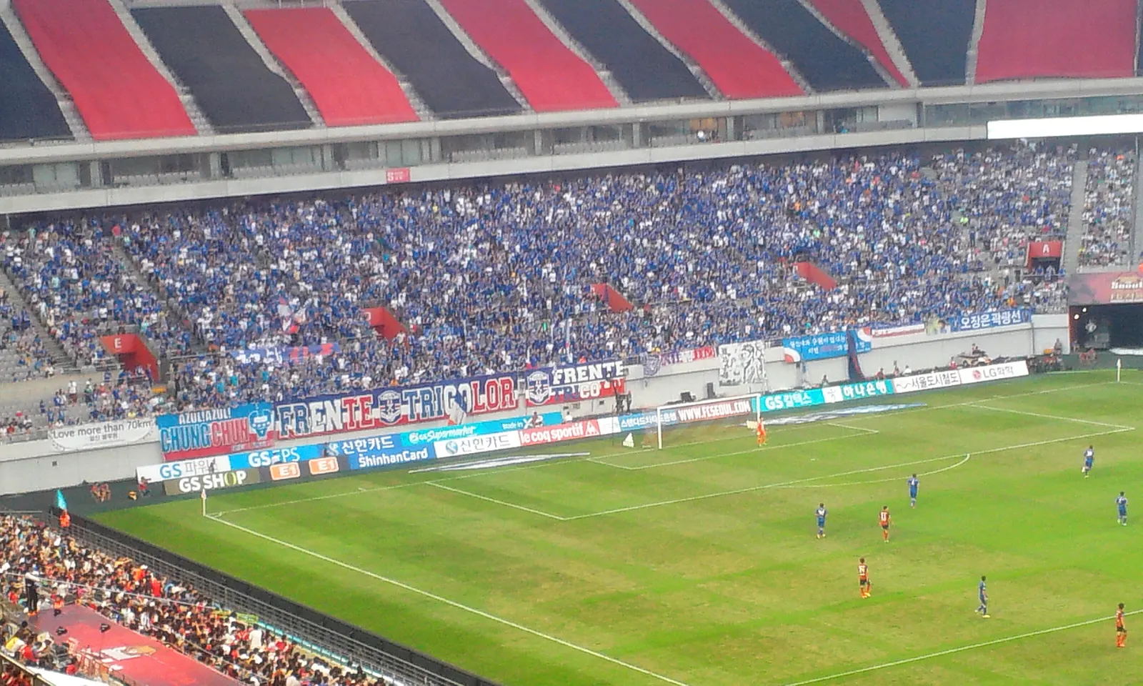 Supporters' groups massed behind the goal with flags and banners at a Super Match