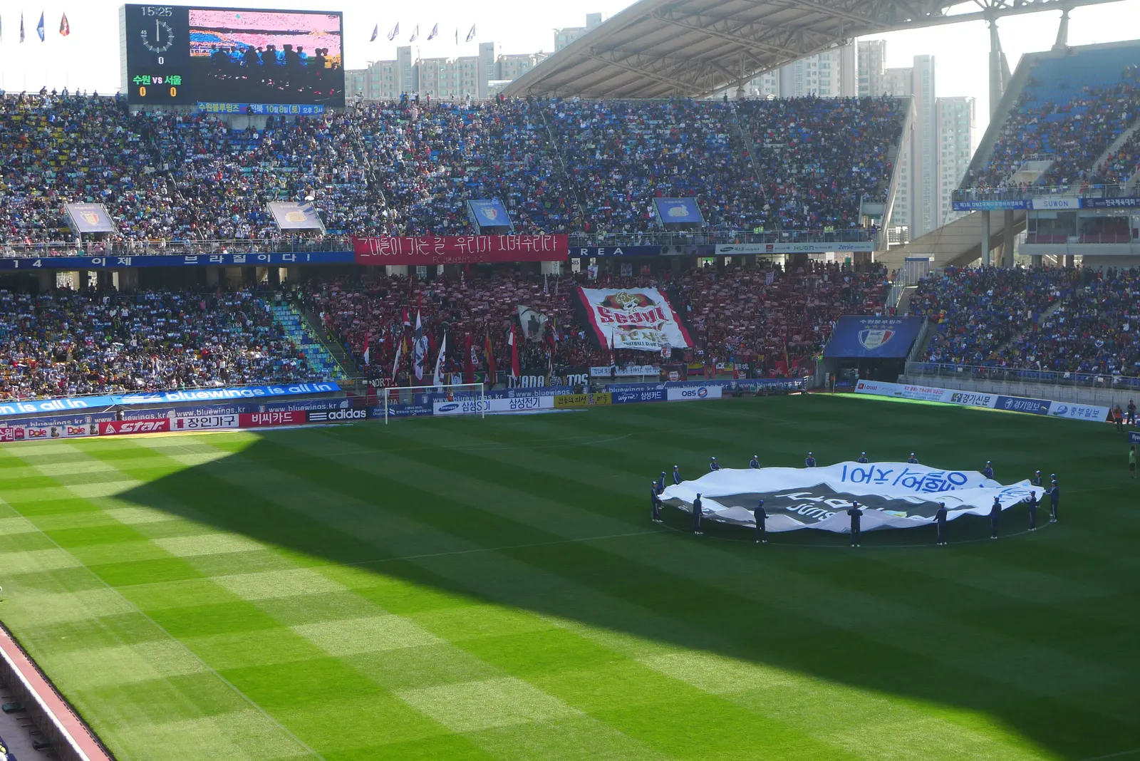 The south stand at Suwon World Cup Stadium photographed from the north end during a Super Match, with the away section in red at the centre